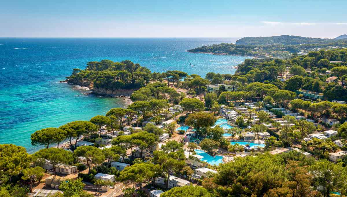 Vue aérienne camping premium Côte d'Azur avec mobil-homes et piscines près plage turquoise