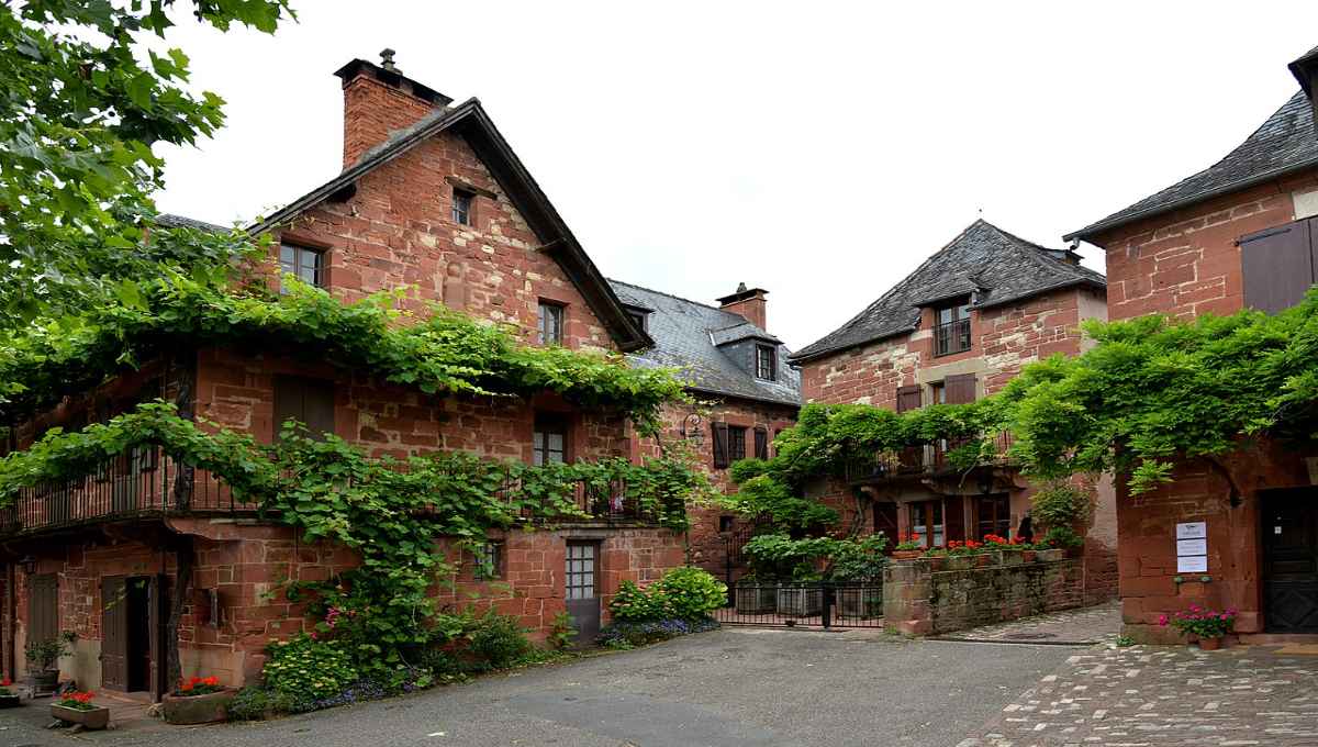 collonges la rouge Rue pavée d'un village médiéval avec maisons en grès rouge et tourelles typiques du patrimoine français