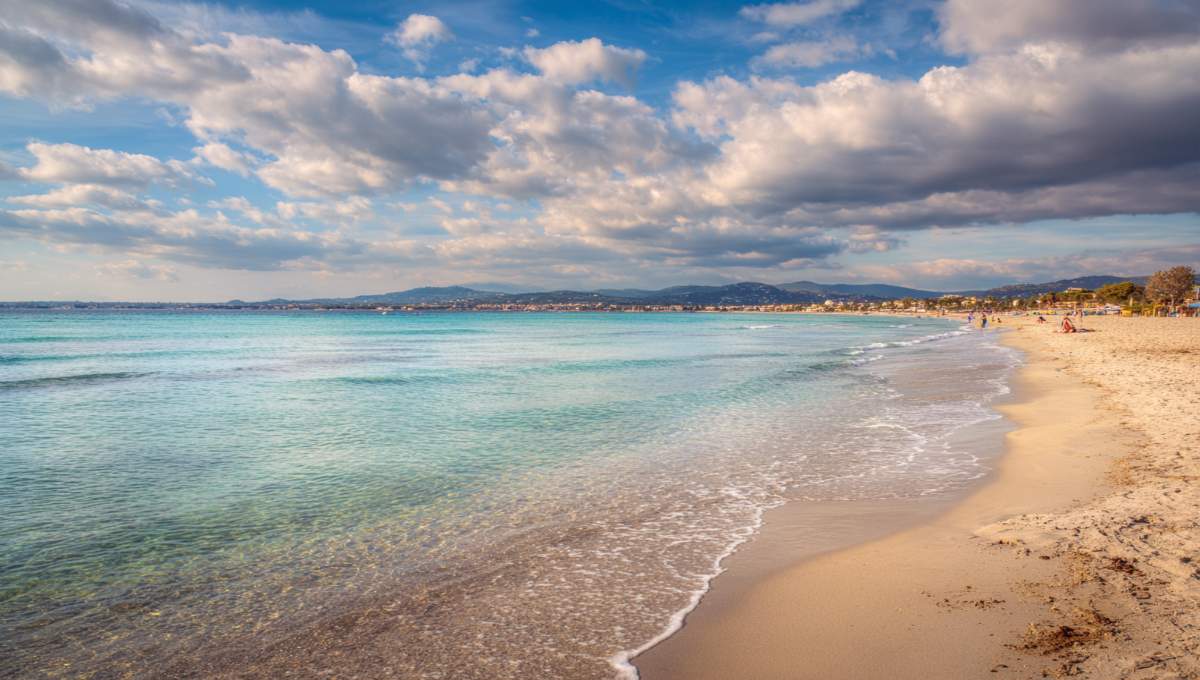 Plage méditerranéenne paisible en automne avec mer turquoise et ciel partiellement ensoleillé