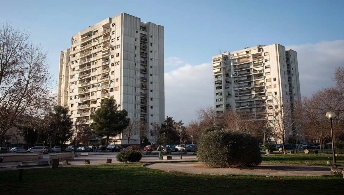 Quartier résidentiel habitat social sud France avec immeubles années 70 et espaces verts